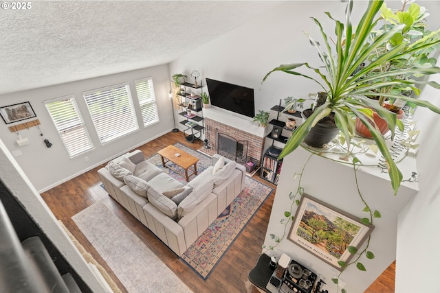 16190 SW Theresa Ct, Beaverton, OR 97007 - living area with a textured ceiling, a brick fireplace, wood finished floors, and baseboards