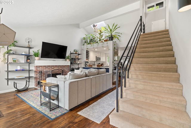 16190 SW Theresa Ct, Beaverton, OR 97007 - living room with stairway, dark wood finished floors, a fireplace, high vaulted ceiling, and baseboards