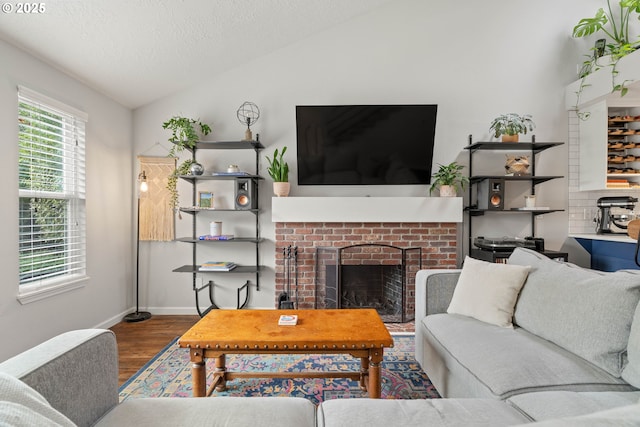 16190 SW Theresa Ct, Beaverton, OR 97007 - living room with lofted ceiling, wood finished floors, baseboards, a fireplace, and a textured ceiling
