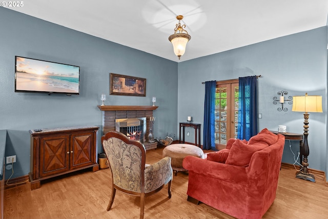living room with light wood-style flooring, a fireplace, and baseboards