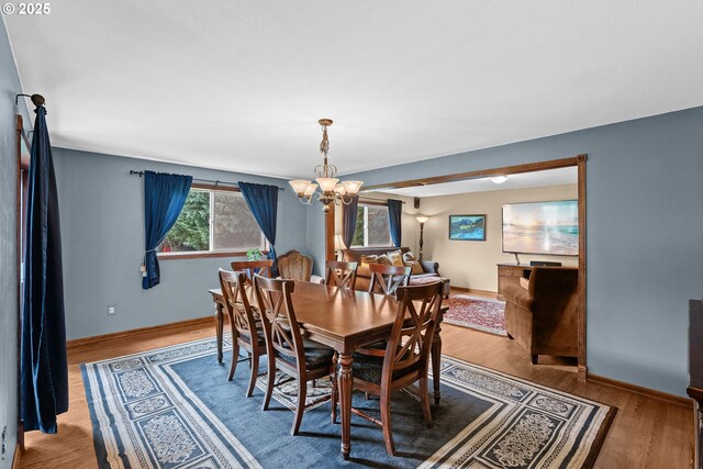 dining room with a chandelier, wood finished floors, and baseboards