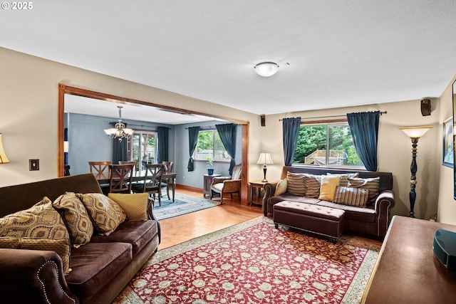 living room featuring a chandelier, plenty of natural light, and wood finished floors