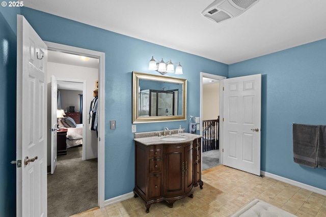bathroom with ensuite bathroom, baseboards, a shower, and vanity