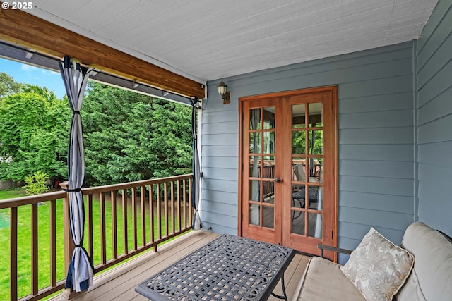 wooden terrace featuring french doors and a lawn