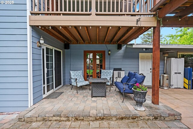 view of patio / terrace featuring a balcony, french doors, and an outdoor living space