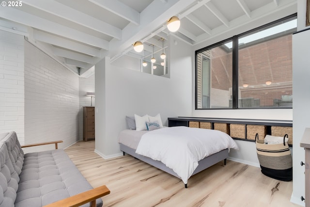 bedroom featuring brick wall, vaulted ceiling with beams, and light hardwood / wood-style flooring