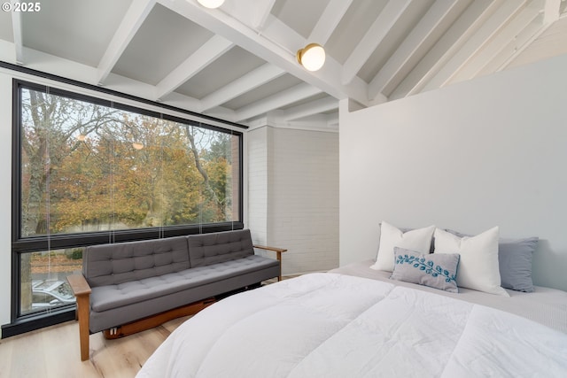 bedroom featuring beamed ceiling and light hardwood / wood-style flooring