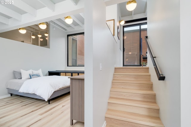 staircase featuring beamed ceiling and wood-type flooring