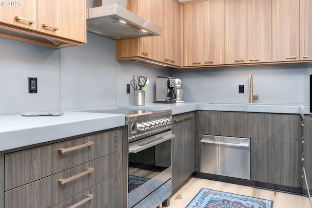 kitchen with light wood-type flooring, stainless steel range with electric stovetop, sink, and exhaust hood