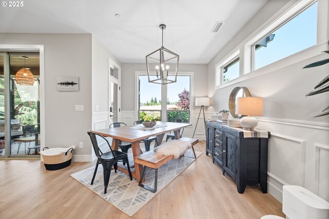 4148 S 11th Cir, Ridgefield, WA 98642 - dining space featuring light wood finished floors, a chandelier, a decorative wall, and a wainscoted wall