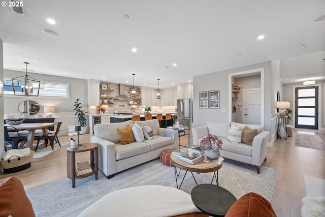 4148 S 11th Cir, Ridgefield, WA 98642 - living area with light wood-style floors, healthy amount of natural light, a chandelier, wine cooler, and recessed lighting