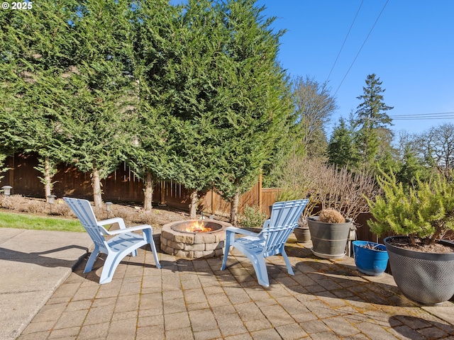 view of patio with a fire pit and fence