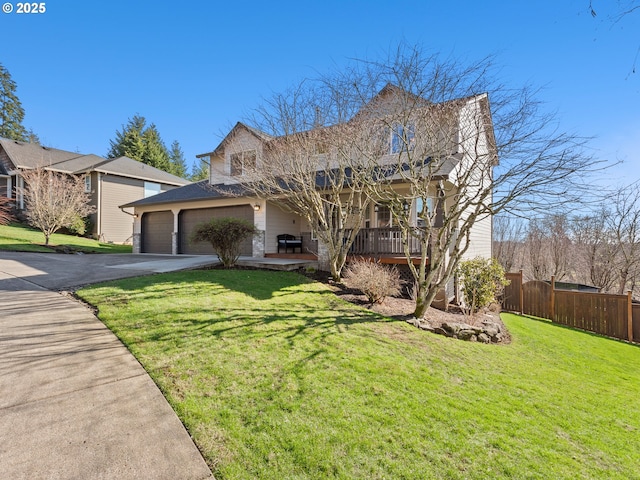 view of front facade with an attached garage, driveway, a front yard, and fence