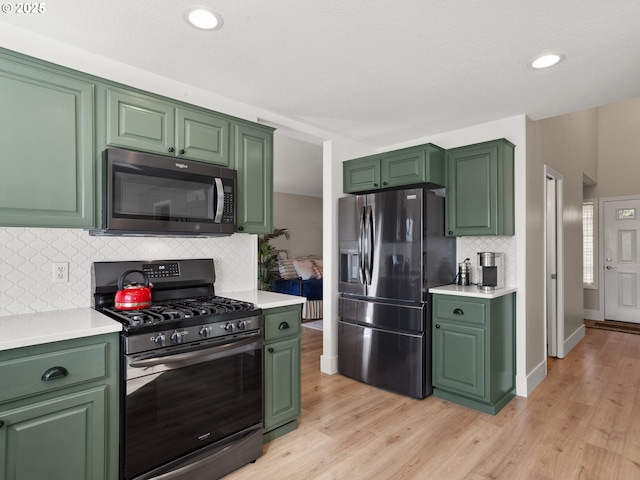 kitchen with stainless steel appliances, light countertops, and green cabinetry