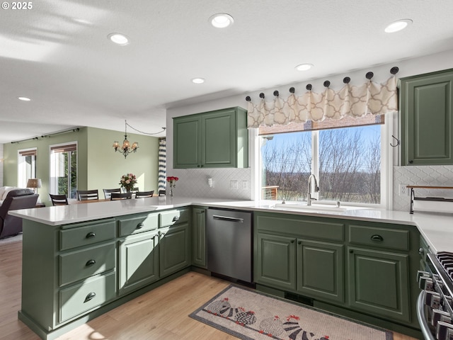 1617 NE 1st St, Battle Ground, WA 98604 - kitchen featuring green cabinetry, appliances with stainless steel finishes, a peninsula, a sink, and light countertops