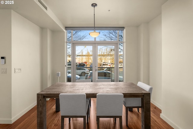 dining room with expansive windows and hardwood / wood-style floors