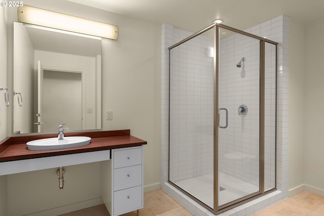 bathroom featuring tile patterned floors, a shower with shower door, and sink