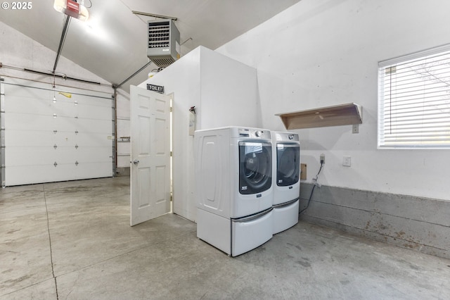 washroom with a garage, laundry area, a heating unit, and washing machine and clothes dryer