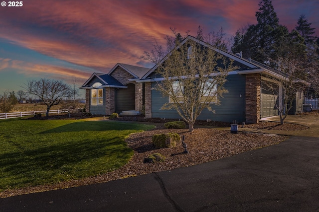 view of front facade with an attached garage, fence, a front lawn, and concrete driveway