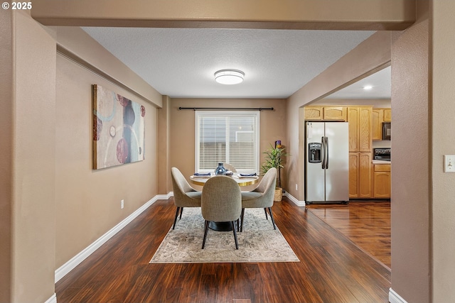 dining room featuring dark wood-type flooring, baseboards, and a textured ceiling