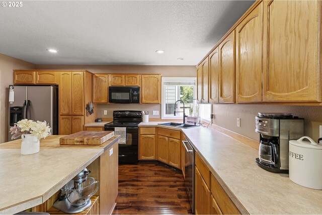 kitchen featuring dark wood-style flooring, recessed lighting, light countertops, black appliances, and a sink
