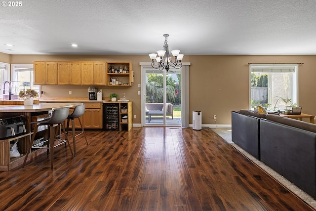 kitchen featuring baseboards, open shelves, an inviting chandelier, dark wood-style flooring, and light countertops