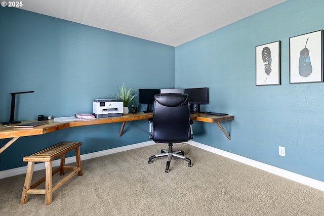 carpeted home office featuring baseboards and a textured ceiling