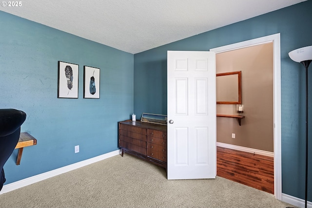 bedroom with light carpet, baseboards, vaulted ceiling, and a textured ceiling