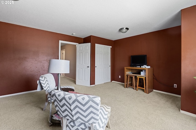 sitting room featuring carpet flooring and baseboards