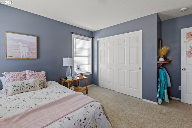 carpeted bedroom with a closet and baseboards