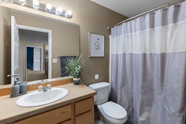 bathroom featuring toilet, curtained shower, and vanity