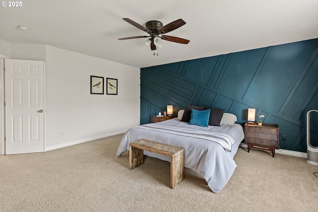 bedroom with a decorative wall, carpet, baseboards, and ceiling fan