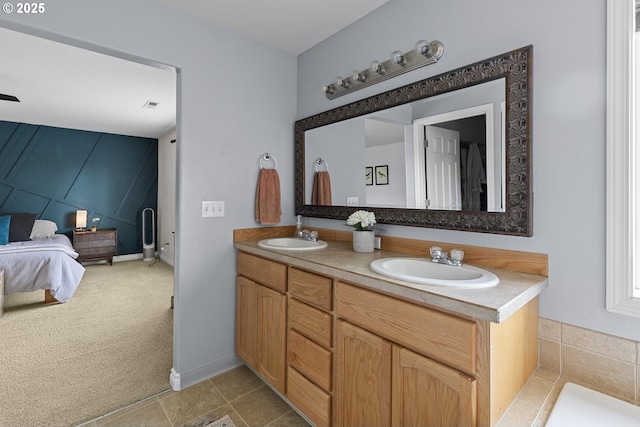 ensuite bathroom featuring double vanity, a sink, and connected bathroom