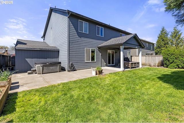 back of house featuring a patio area, a yard, fence, and a hot tub