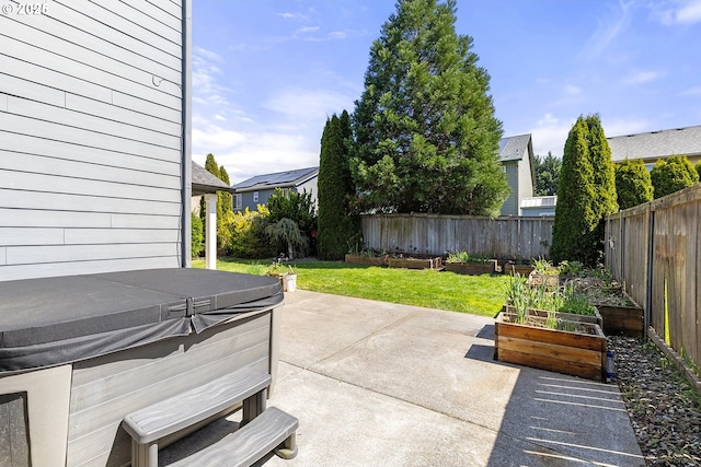 view of patio / terrace featuring a garden, a fenced backyard, and a hot tub