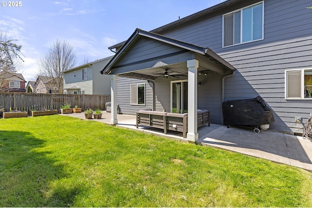 rear view of property featuring ceiling fan, a vegetable garden, a lawn, a patio area, and fence