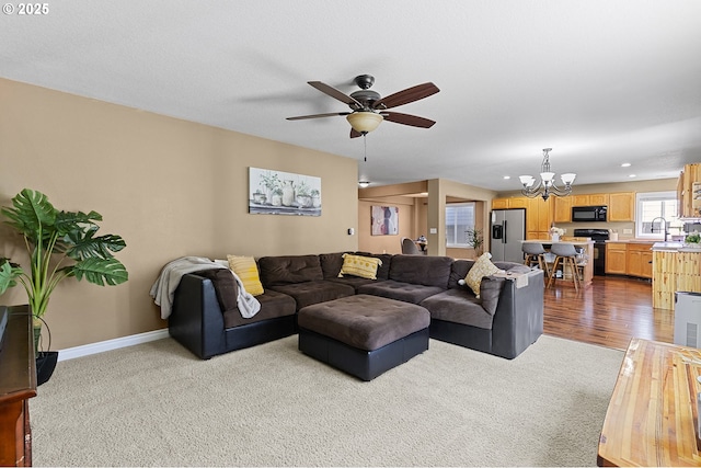 living room with recessed lighting, carpet, ceiling fan with notable chandelier, and baseboards