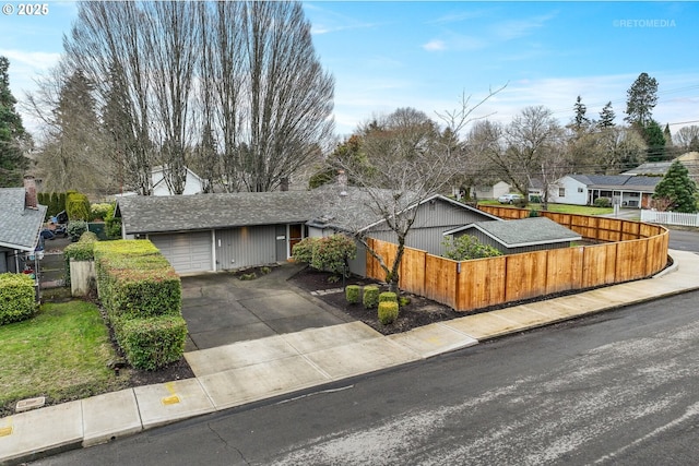 ranch-style home featuring fence, concrete driveway, and a garage