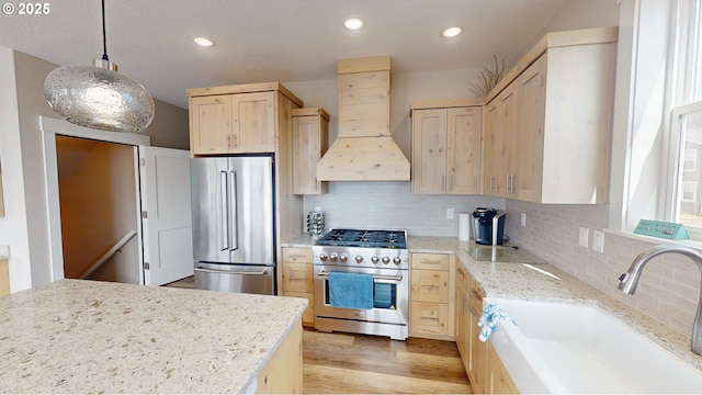 6604 NE Logan Rd, Lincoln City, OR 97367 - kitchen with premium appliances, custom exhaust hood, light brown cabinetry, tasteful backsplash, and light wood-type flooring