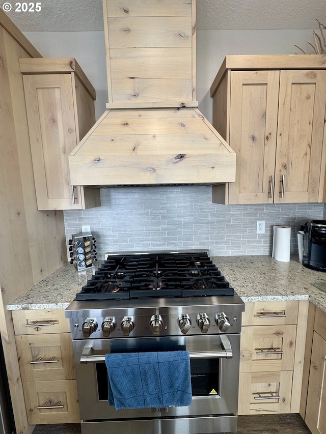 6604 NE Logan Rd, Lincoln City, OR 97367 - kitchen featuring stainless steel gas range oven, light brown cabinetry, tasteful backsplash, range hood, and a textured ceiling