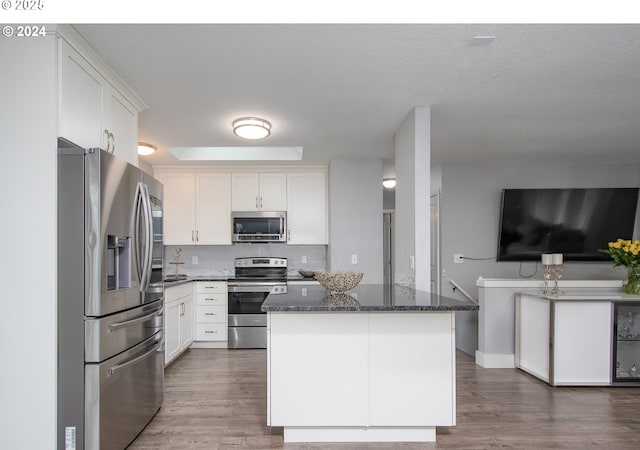 kitchen with white cabinets, dark stone counters, and stainless steel appliances