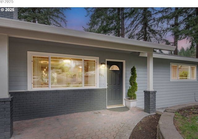 view of exterior entry with brick siding