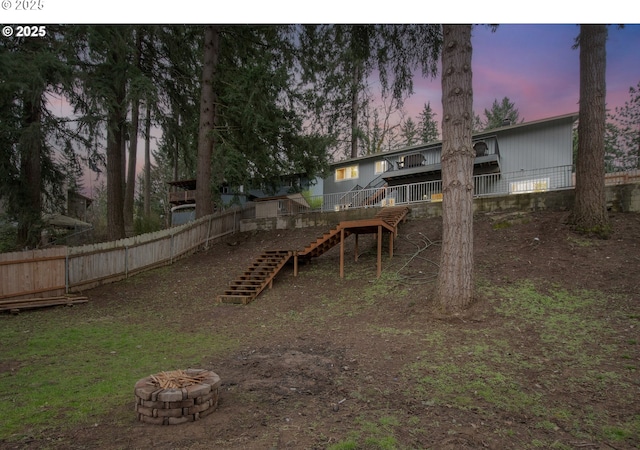 yard at dusk with a fire pit and a wooden deck