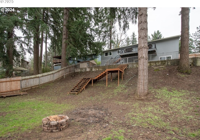 view of yard with a deck and a fire pit