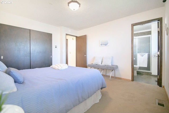 bedroom featuring a closet, light colored carpet, visible vents, ensuite bathroom, and a textured ceiling