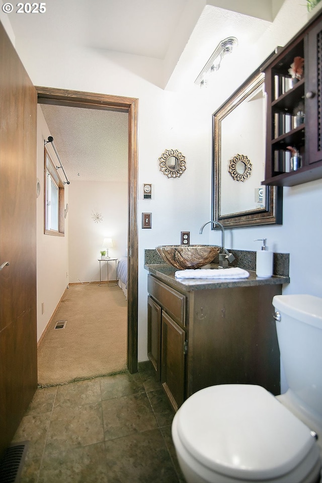 bathroom featuring visible vents, a textured ceiling, vanity, and toilet