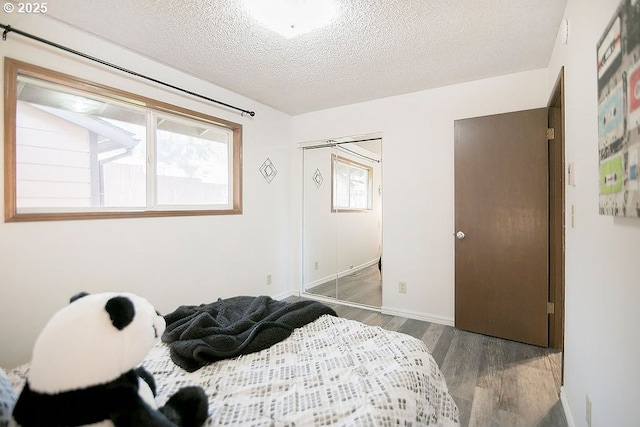 bedroom with a textured ceiling and wood finished floors