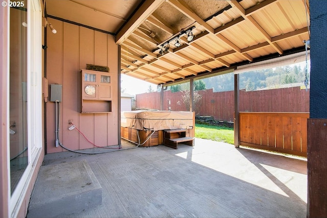 view of patio with fence and a hot tub