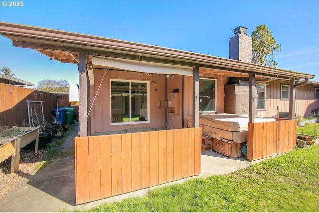 exterior space with a garden, fence, and a chimney