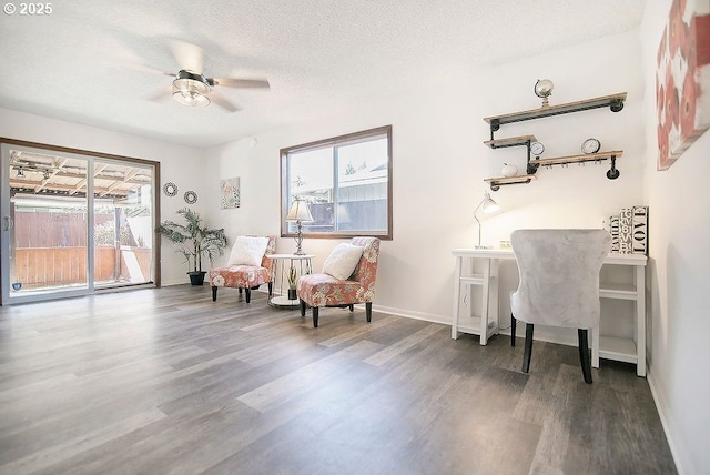 sitting room with a textured ceiling, plenty of natural light, wood finished floors, and baseboards